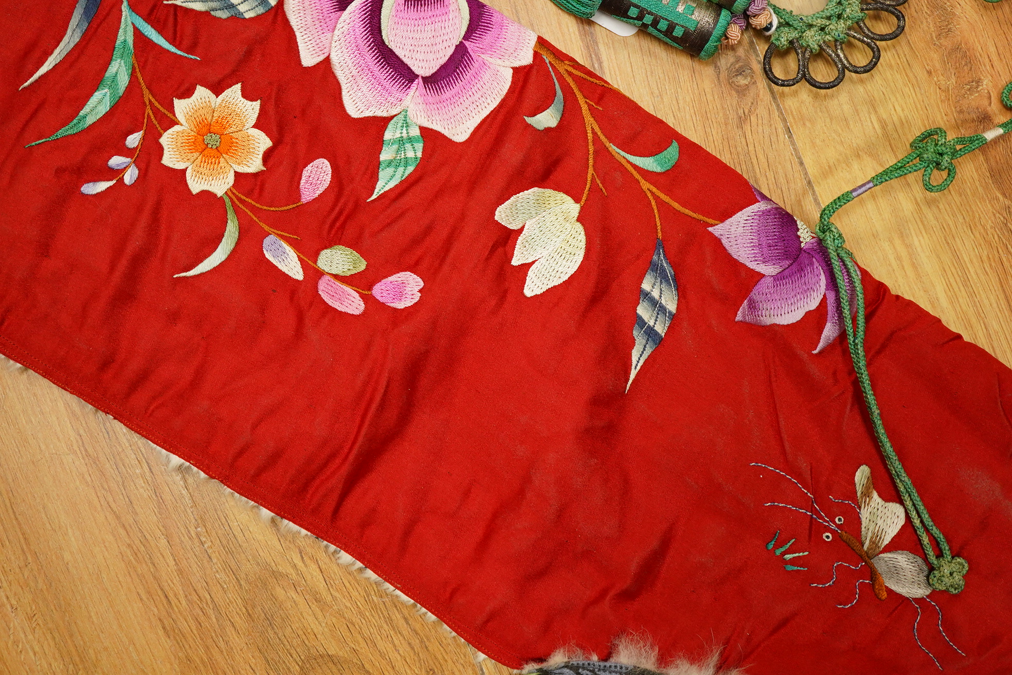 A 20th century possibly Miao, child’s multi coloured silk embroidered and padded winter hood, with fur trim and ornate tasselled decoration, 54cm long. Condition - the light green silk edge has worn and has lightly disco